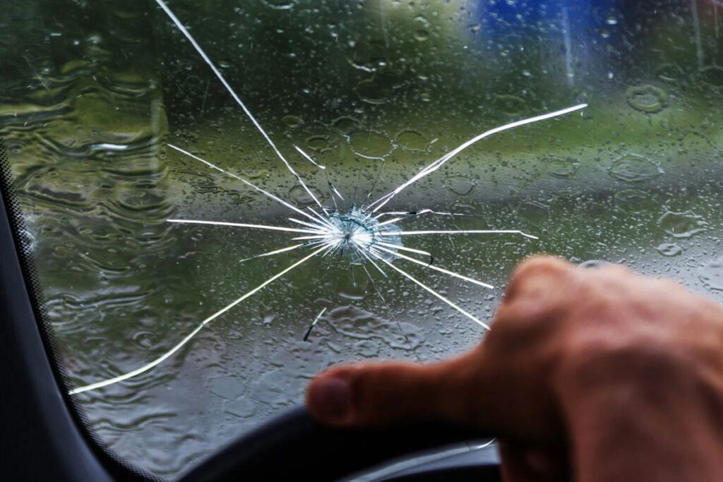Technician installing a new windshield showing factors that affect replacement cost